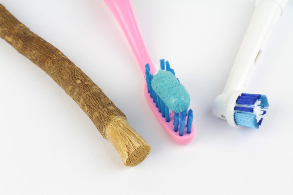Miswak twig, traditional toothbrush, and electric toothbrush on white background Miswak twig, traditional toothbrush, and electric toothbrush on white background