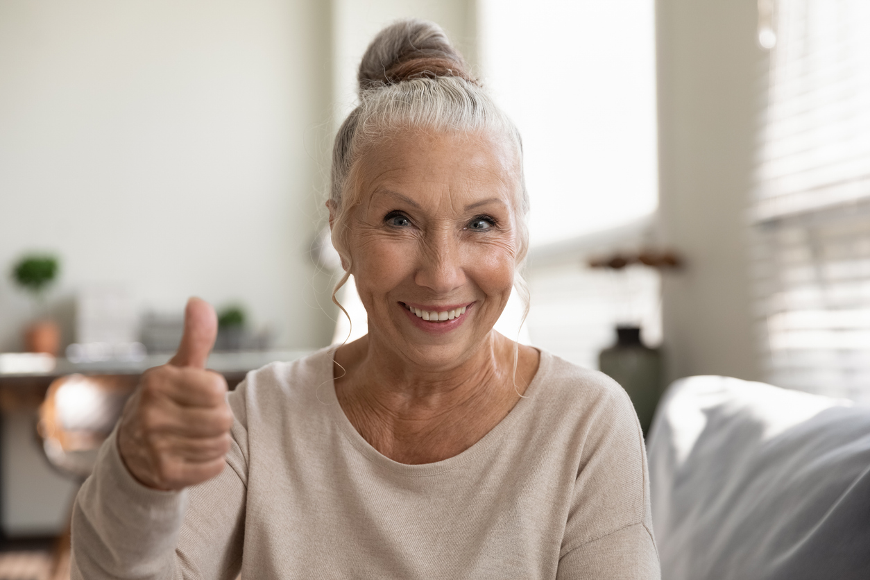 Happy positive elderly woman making like gesture, showing thumb up at camera with toothy smile, recommending dental clinic, health medical insurance service. Satisfied senior client head shot portrait